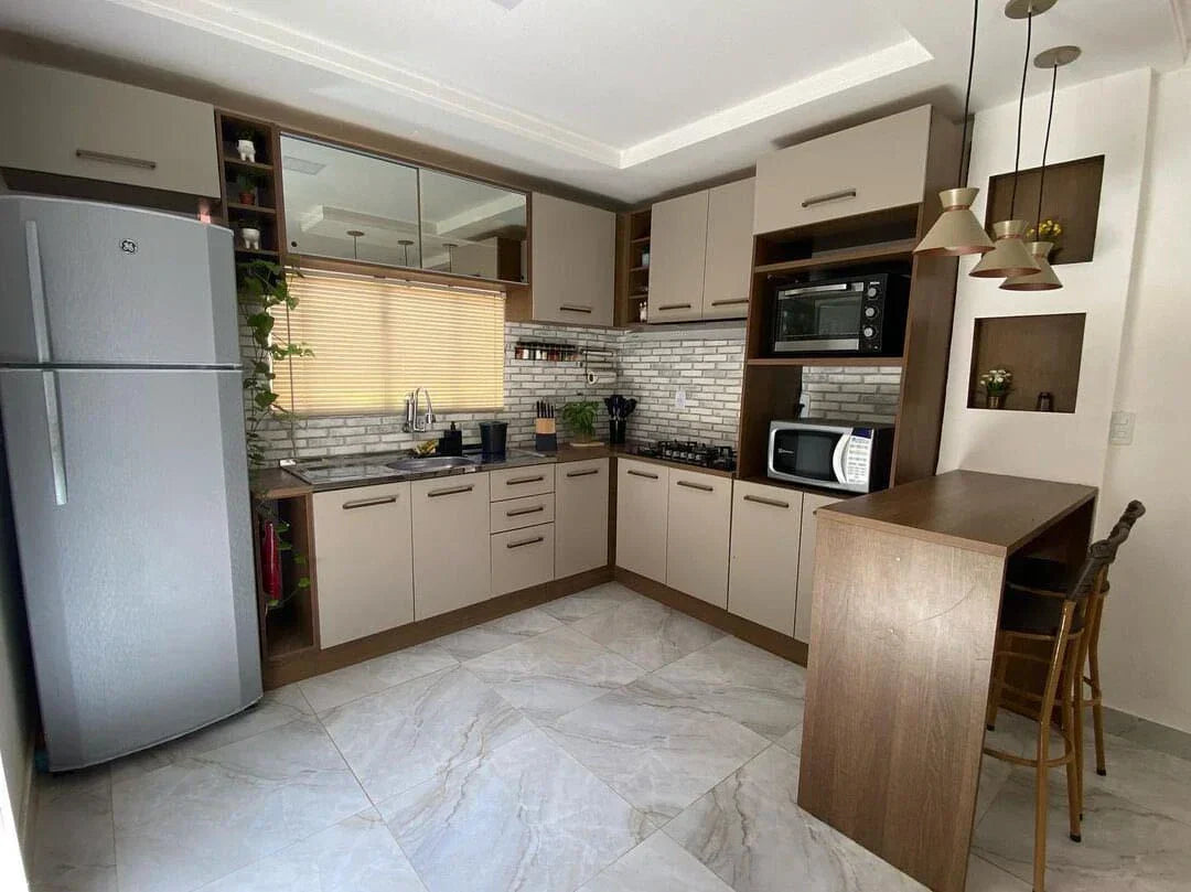 Cocina organizada y luminosa en tonos beige, con diseño funcional y gabinetes bien distribuidos.