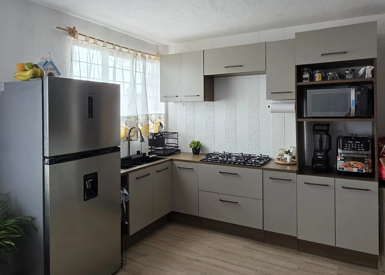 Ideas de cocina integral moderna en gris con cubierta de madera y refrigerador de acero